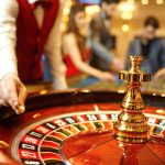 The croupier holds a roulette ball in a casino in his hand. Gambling in a casino.